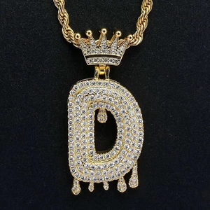 Close-up of hip hop crown letter D pendant with white zircon and gold twisted rope chain
