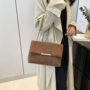 Brown corduroy shoulder bag with red strawberry pattern and gold chain strap detail
