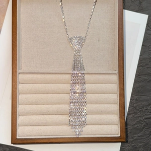 Collier cravate argenté scintillant avec strass et franges dans un écrin à bijoux