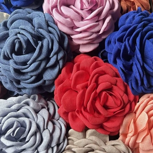 Detailed close-up of multi-layered fabric rose hair clips in vibrant diverse colors