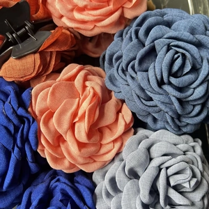 Macro detail of multi-colored fabric rose hair claws with layered petal textures