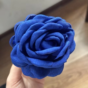 Detailed close-up of dark blue fabric rose hair claw showing multilayered fabric texture