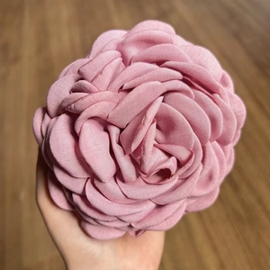 Detail view of large pink fabric rose hair claw clip handmade with satin-like layers