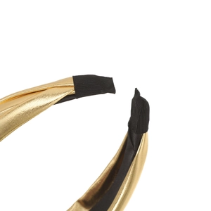 Detail of gold metallic knotted headband showing black threaded fabric wrap at the end