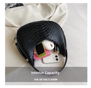 Detail view of crescent bag interior showing capacity for smartphone and sunglasses