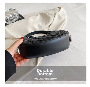 Detail showing crocodile-embossed faux leather and silver buckle on black crescent bag