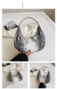 Detail of white snake-patterned crescent bag featuring textured faux leather and zip closure