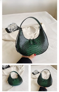 Detail of green hobo bag with snakeskin texture and silver zipper hardware