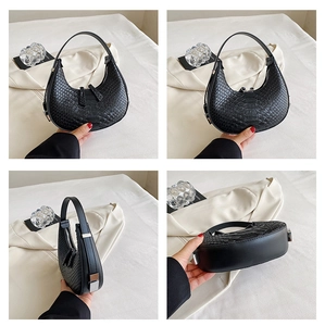 Detail shots of black crocodile pattern crescent bag with silver hardware on white background
