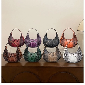 Multiple colors of crocodile pattern crescent shoulder bags displayed on a wooden shelf