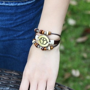 Detail showing layers of leather cords and wood beads with a metal peace sign charm
