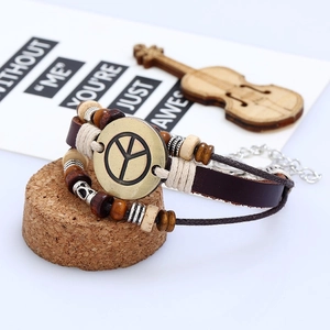 Close-up of multilayer braided leather bracelet with peace sign and wood beads
