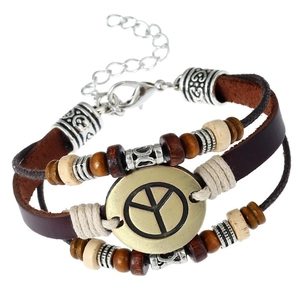 Detail of bohemian punk leather bracelet featuring beaded layers and peace sign charm