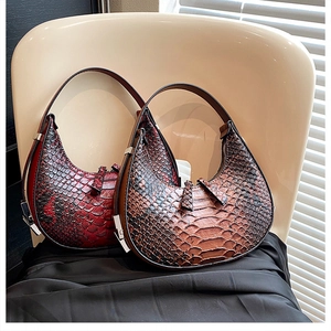 Detail of burgundy and dark brown crescent bags with embossed faux crocodile texture