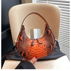 Detail of the orange and black snakeskin hobo bag with a stylish crescent shape and zipper