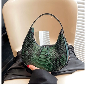 Detailed view of green snakeskin pattern texture on the crescent moon shaped shoulder bag