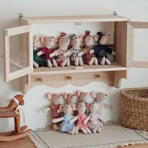 Detailed view of cute dressable plush mouse dolls displayed in a cozy wooden cabinet setup.