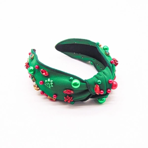 Detail of green velvet Christmas headband with red pearls and sparkling rhinestones