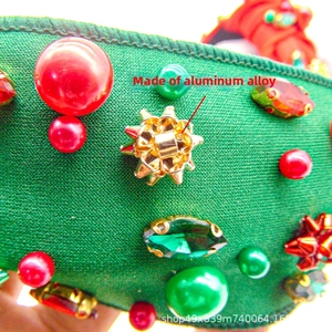 Detail of Christmas headband with green fabric, red pearls, and star rhinestones