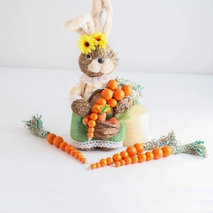 Detail of Easter sisal bunny figurine wearing a floral shirt with carrot wood bead tassels