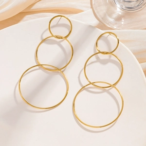 Detail view of triple layered gold-plated stainless steel hoop earrings on satin