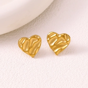 Detailed close-up of golden heart earrings with unique textured crumpled finish