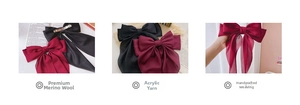 Detail of handmade knit bow hair clips in wine red and black on a rustic tray