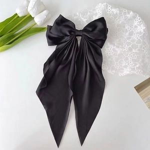 Elegante lazo negro grande de satén para el pelo con cintas largas y acabado de seda