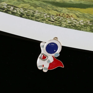 Detailed view of a cute cartoon astronaut charm with red cape and gold alloy framing
