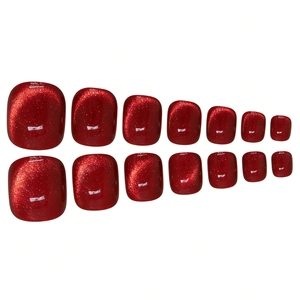 Macro detail of 14 ruby red cat-eye press-on toenails with shimmering glitter texture