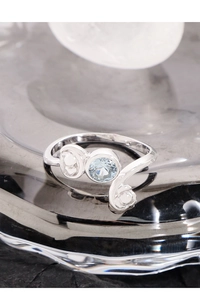 Macro shot of S925 silver bypass ring featuring a round light blue zircon gemstone