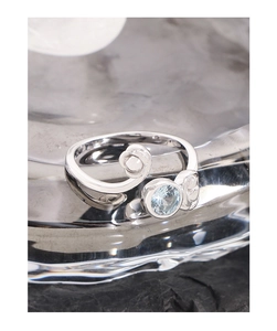 Macro shot of S925 silver spiral open ring with light blue zircon and polished finish