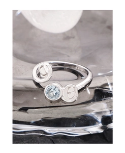Macro shot of S925 silver ring featuring round light blue zircon and scrollwork detail
