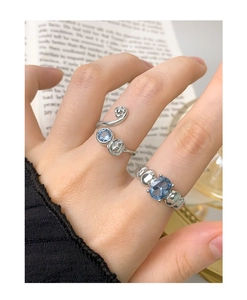 Close-up of S925 silver rings with sea blue zircon and metal beads on hand