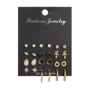 Macro detail of multi-piece gold earring set with pearls and rhinestones on card