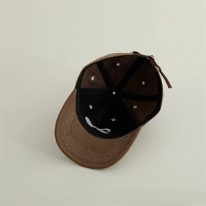 Vista interna del cappellino in cotone marrone con nastro nero e fibbia in metallo regolabile