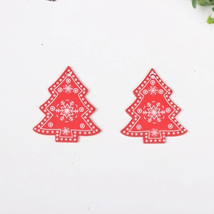 Pair of red wooden Christmas tree ornaments with white snowflake patterns and dot prints