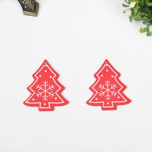 Detail of two red wooden Christmas tree ornaments with white snowflake patterns