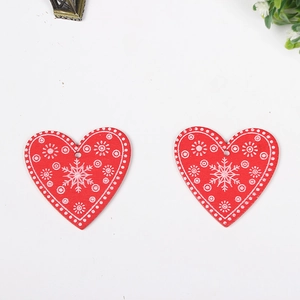 Close-up of red wooden heart ornaments with snowflake patterns and pre-drilled holes