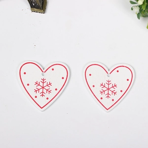 Set of two heart-shaped wooden Christmas ornaments with snowflake patterns on white background