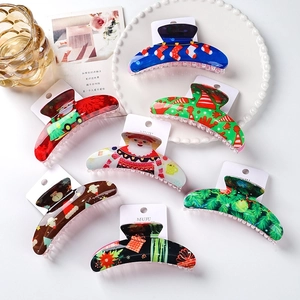 Set of six Christmas acrylic hair claws with Santa and reindeer motifs on display cards