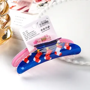 Christmas themed large hair claw clip in navy and pink with festive holiday stocking patterns