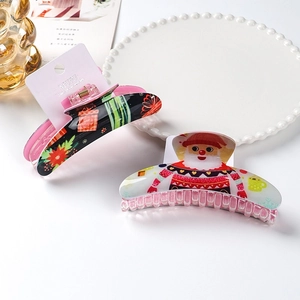 Detail of Christmas claw clips set with Santa Claus and gift patterns on pink cards