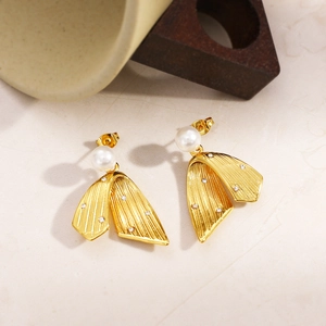 Macro detail of vintage gold pearl earrings with crystal accents and leaf texture