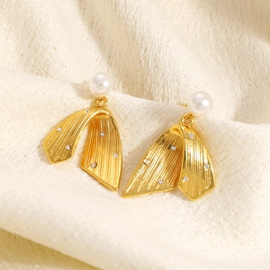 Irregular textured 18K gold earrings with pearls and crystals on beige fabric
