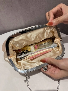 Interior view of champagne satin evening clutch bag with metal chain and large clasp