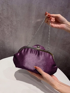 Detail of elegant purple satin clutch with silver metal frame and sphere clasp closure
