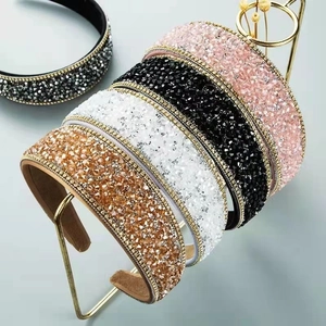 Sparkling wide headbands with crystals in four colors on a metal display rack
