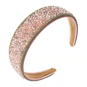 Pink wide headband with sparkling crystal beads and gold chain trim in a flat lay view