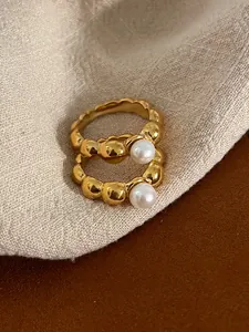 Detailed view of two vintage gold bubble rings with elegant white freshwater pearls